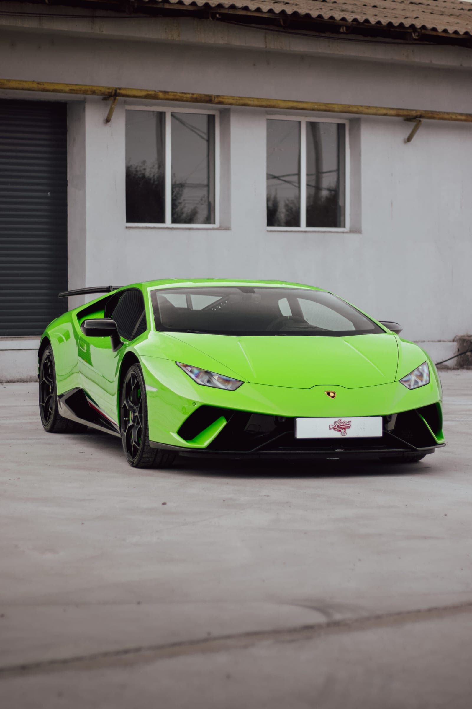 Lamborghini Huracán verde în fața atelierului
