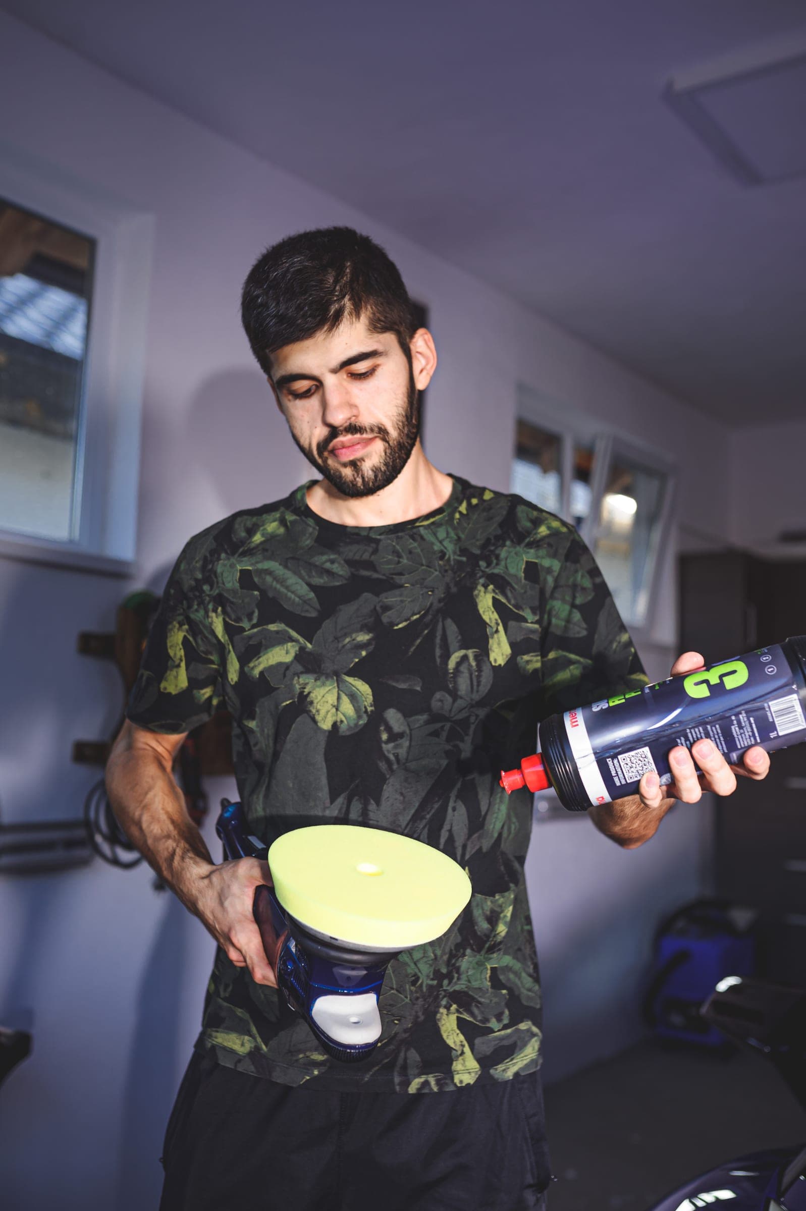 Tehnician Alpina cu un burete de polish și un produs Gyeon în mână