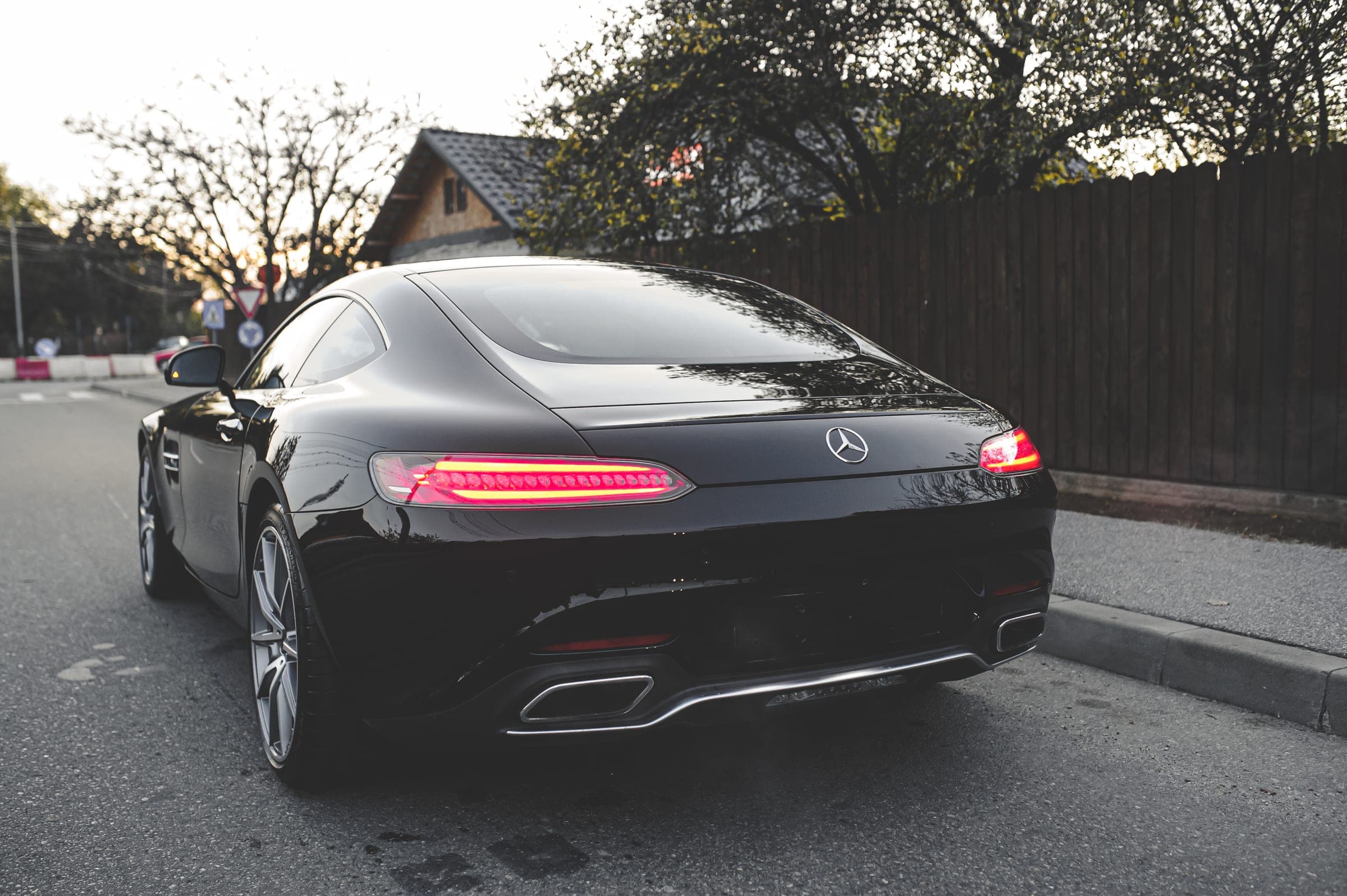 Spatele unui Mercedes-AMG GT negru, cu stopurile aprinse