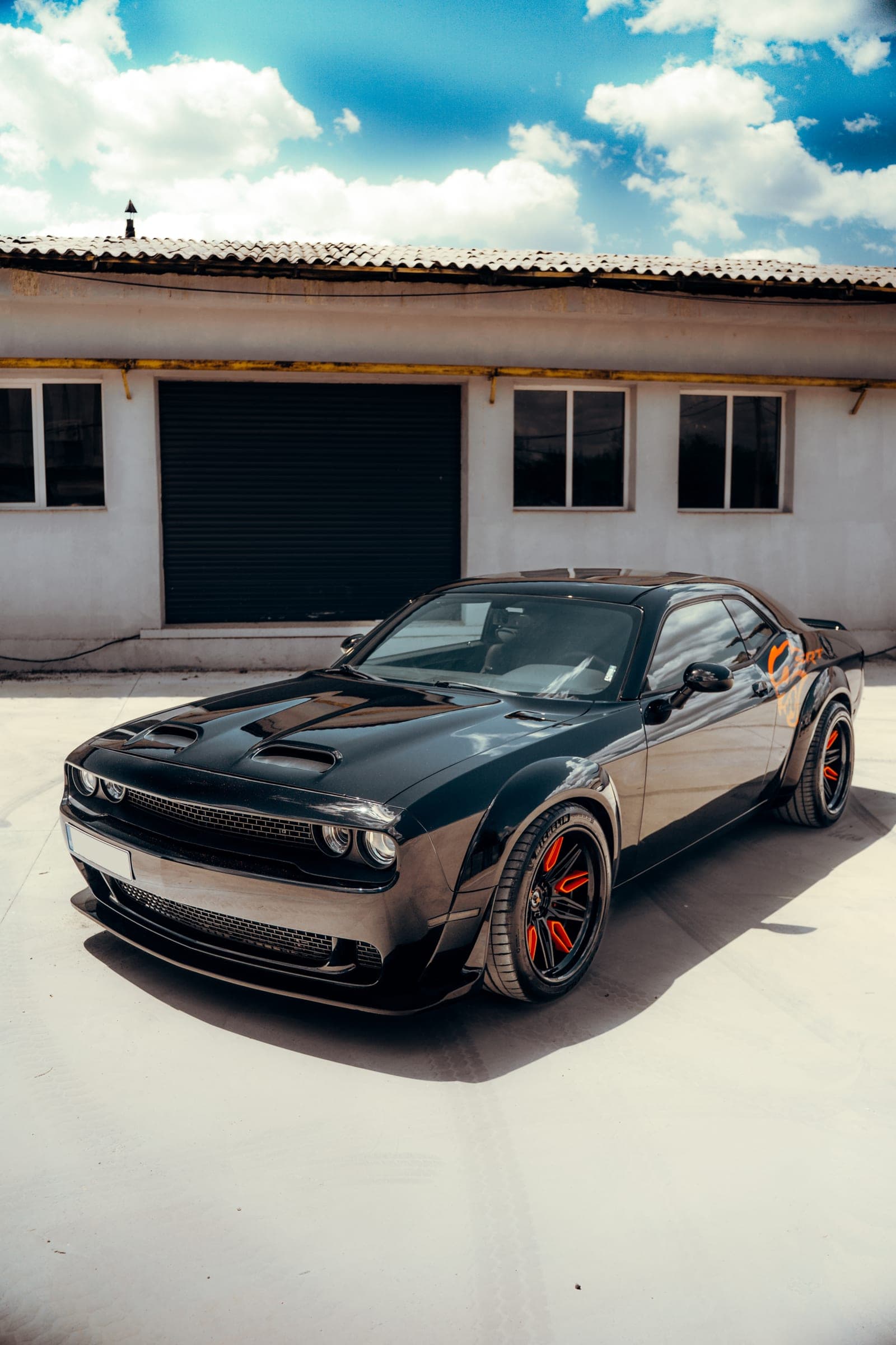 Dodge Challenger gri în fața unei hale