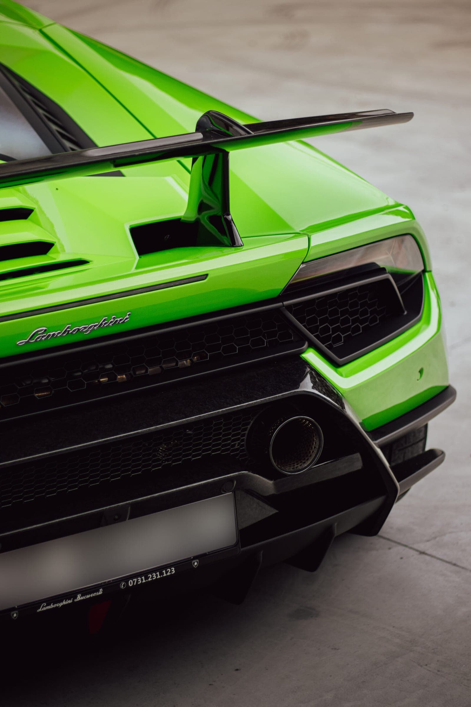 Spatele unui Lamborghini Huracán verde, cu eleronul mare