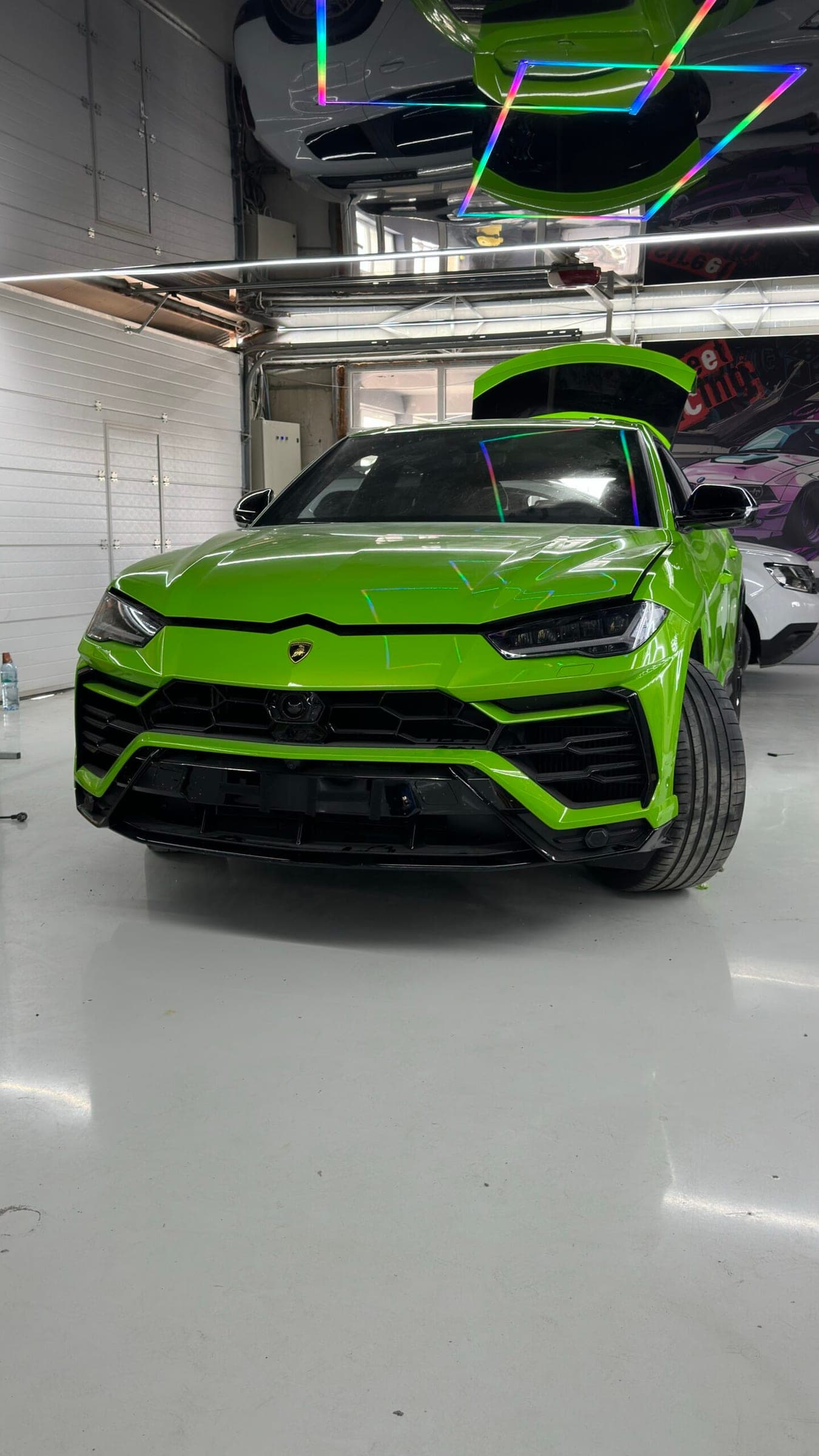 Lamborghini Urus verde în atelier, cu portbagajul deschis